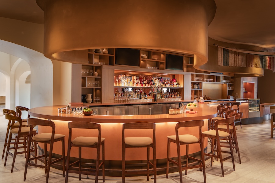 Барная зона с круглой стойкой и подсветкой Kimpton Miralina Resort & Villas Opens