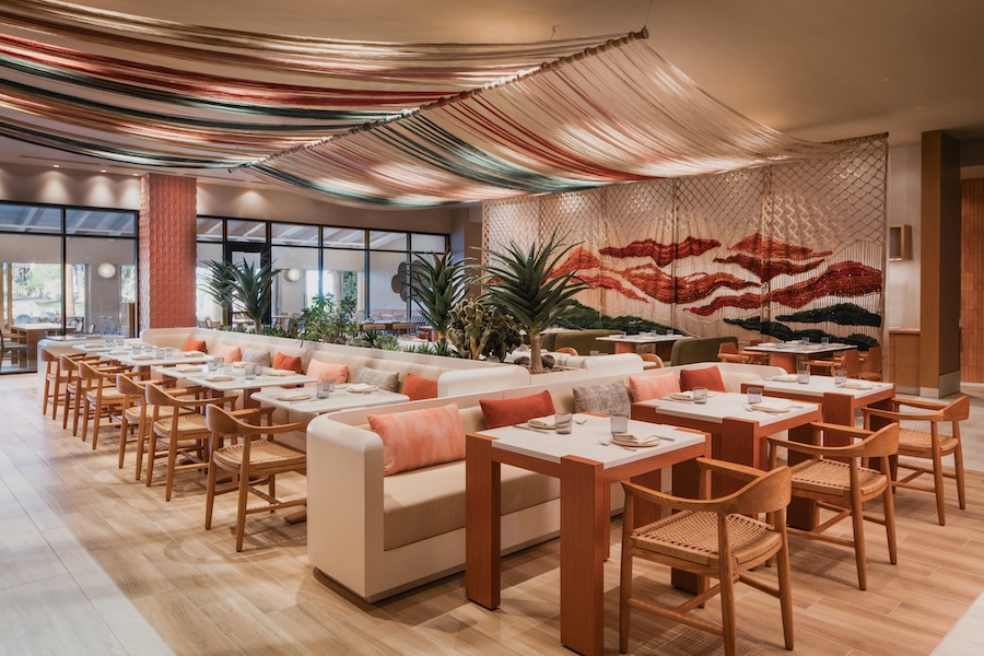 Интерьер ресторана с мягкими диванами и растениями Kimpton Miralina Resort & Villas Opens