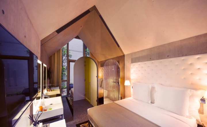 Большая кровать с белоснежным изголовьем в люксе отеля M Social Singapore