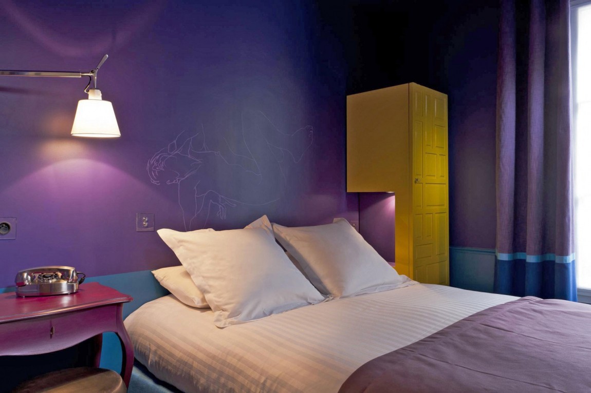 Спальня в фиолетовом цвете в номере Hôtel Le Crayon