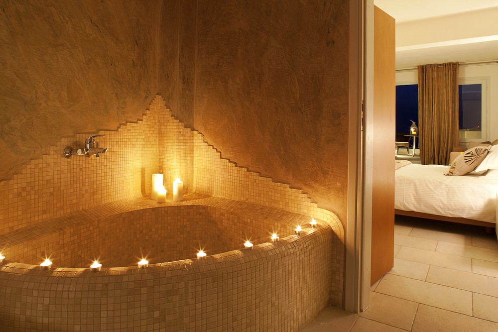 Мягкое мерцание свечей в ванной номера в Aqua Vista Hotels